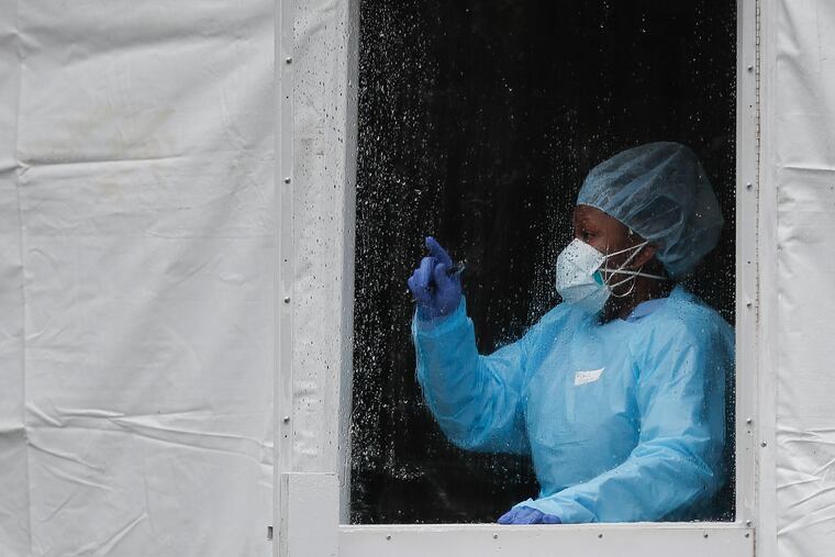 A medical worker gestures at a COVID-19 testing station at the Brooklyn Hospital Center on Monday.