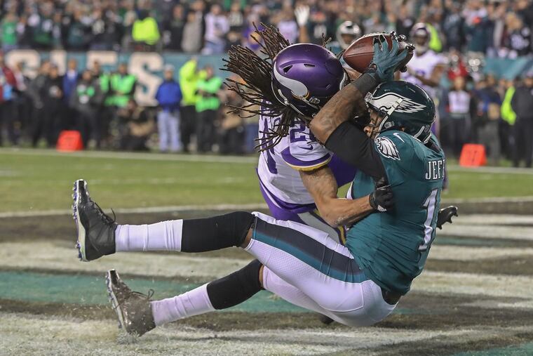 Absorbing a hit from Minnesota's Trae Waynes, Alshon Jeffery scores a fourth-quarter touchdown.