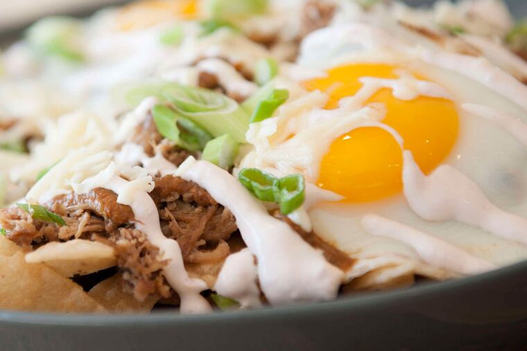The huevos rancheros at the Blue Duck in Northeast Philadelphia incorporates eggs with Cooper American cheese, corn tortilla chips, shredded duck, salsa morita, and strawberry crema.
