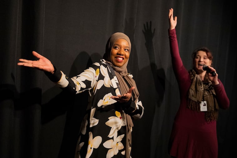 Ameenah Muhammad-Diggins (left), a local Philly author, and Danielle Defassio, manager of studio and performing arts at the Please Touch Museum, gesture toward the actors after a members-only performance of Muhammad-Diggins' story, "Bashirah and the Amazing Bean Pie."