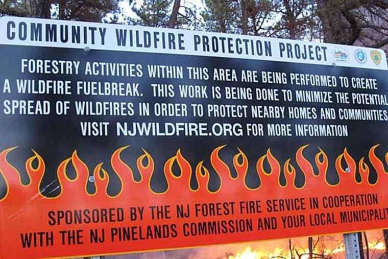 A sign from 2012 describes a prescribed fire in the Pinelands in Lacey Township. Environmentalists say the approach is flawed, but advocates say some efforts must be taken to aid the state's forests. (AP photo)