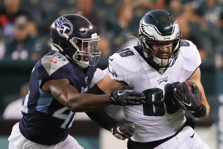 Eagles tight end Dallas Goedert runs with the football against Tennessee Titans defensive back Joshua Kalu during the first quarter.