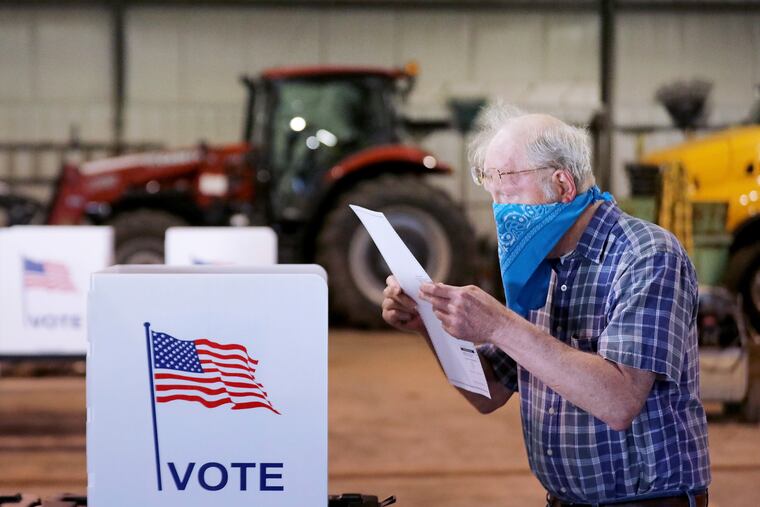 A voter in Wisconsin reviews his ballot while voting Tuesday, April 7, 2020, during the coronavirus pandemic.