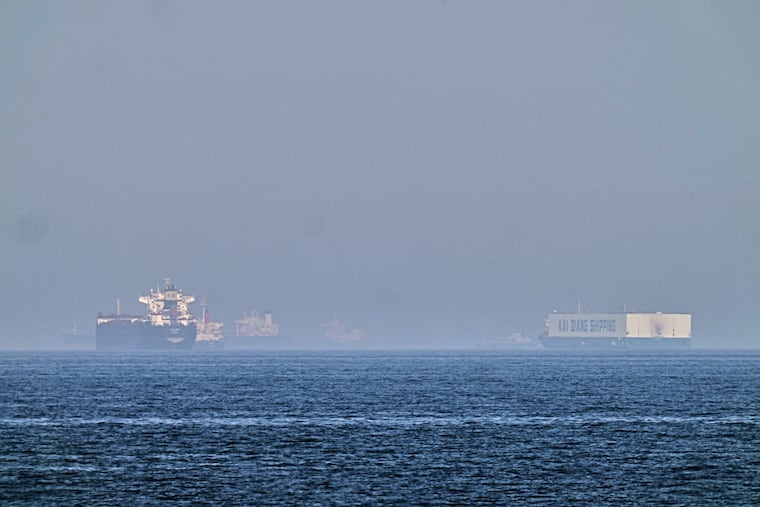 A tanker, left, and a car carrier are anchored at sea in the Gulf of Oman near the Strait of Hormuz, as seen from the coast near Khor Fakkan, United Arab Emirates, Friday, May 1, 2026.