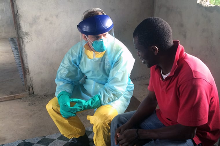 Dan Kelly explains to a patient suspected of having Ebola why Dan wears protective gear. Kelly returned to the University of California - San Francsico this week after a month in the West African country, epicenter of the Ebola outbreak. (courtesy photo)