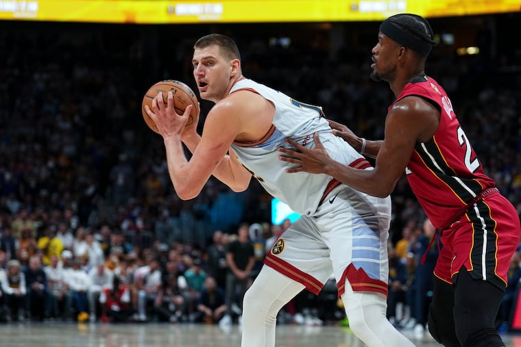 Denver Nuggets center Nikola Jokic, left, is defended by Miami Heat forward Jimmy Butler, right, during the second half of Game 5 of basketball's NBA Finals.