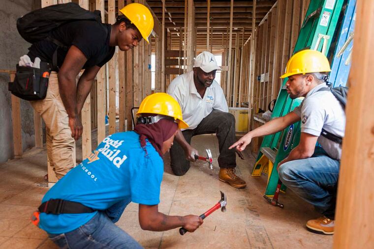 George Jenkins, an instructor for Youth Build Charter School (right), giving a lesson on how to drive nails. The city's next mayor should tailor economic policy to match the skills of the workforce. It's an effort on two fronts: improving particular skill levels of workers, and creating jobs for those skills.
