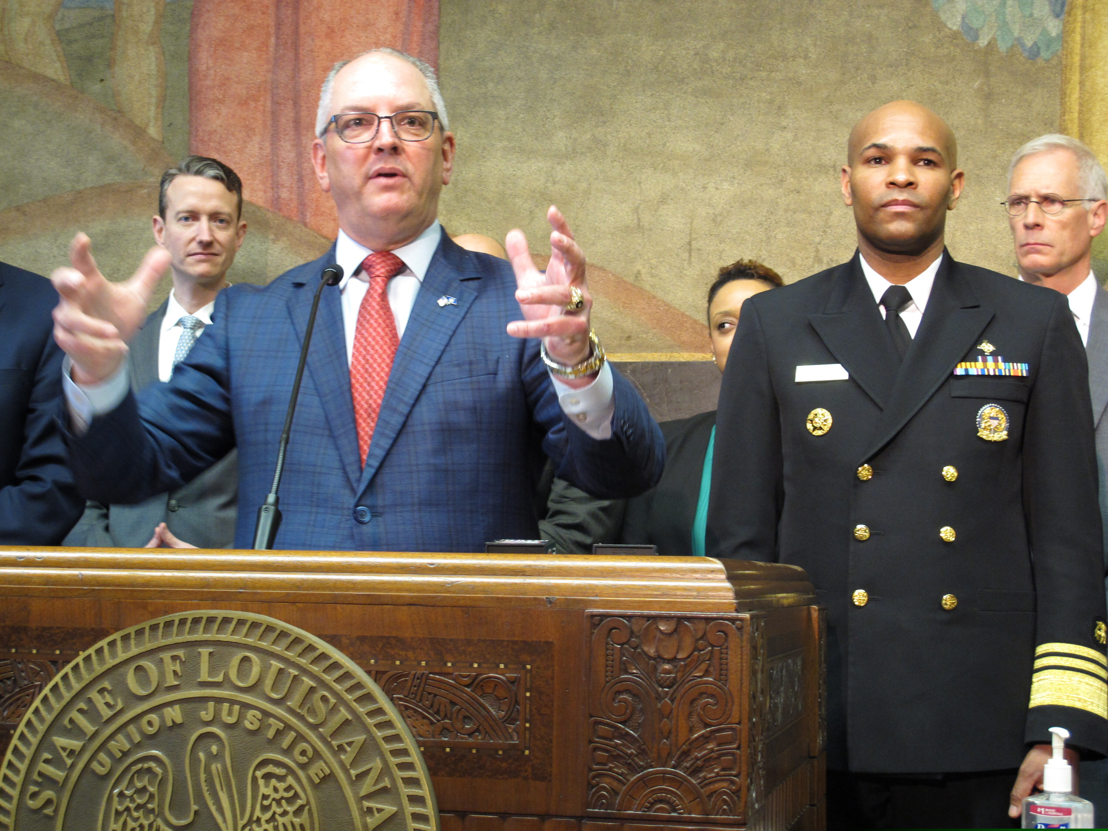 Louisiana Gov. John Bel Edwards speaks about the new coronavirus while U.S. Surgeon General Jerome Adams, right, listens on Thursday, March 12, 2020, in Baton Rouge, La. The number of cases of the COVID-19 disease caused by the virus are on the rise in Louisiana.