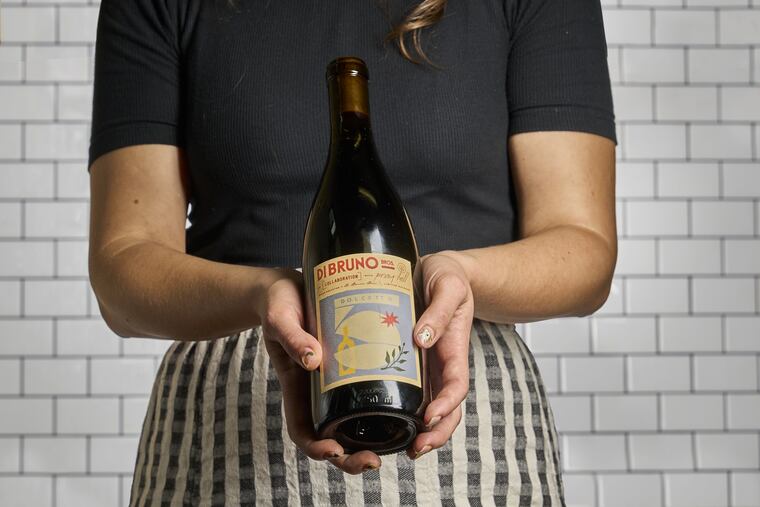A Dolcetto from Oregon's Pray Tell, the latest in a wine collaboration series from Di Bruno Bros., is held by Sande Friedman, the beverage buyer for Di Bruno's who also had an active role in making the wine.