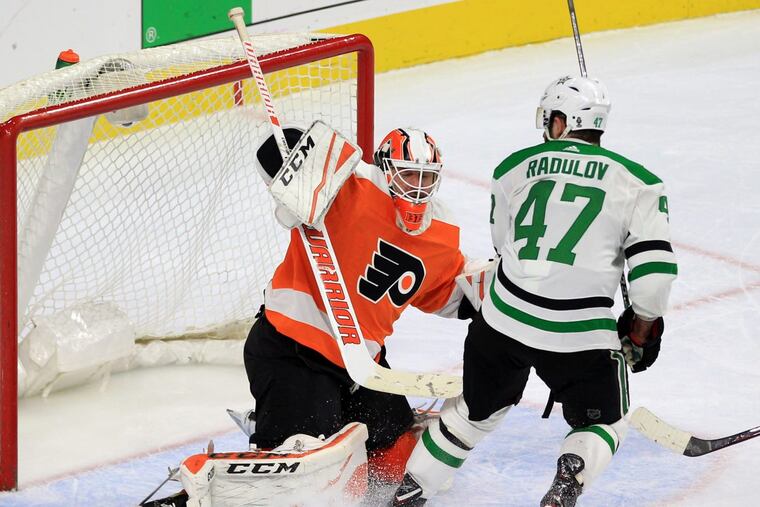 Brian Elliott, left, stops a shot by Alexander Radulov in overtime, helping the Flyers post a 2-1 win Saturday.