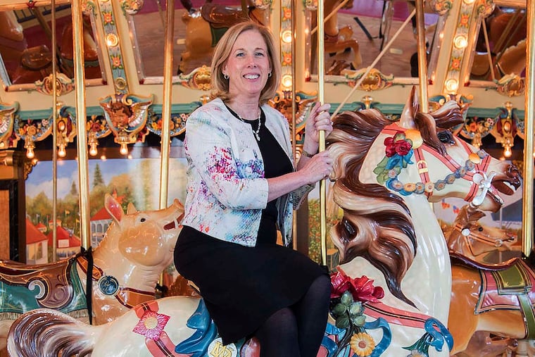 Please Touch Museum president and CEO Patricia Wellenbach on the carousel.
