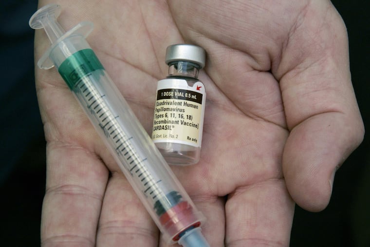 FILE – In this Aug. 28, 2006 file photo, a doctor holds a vial of the human papillomavirus (HPV) vaccine Gardasil in his office.