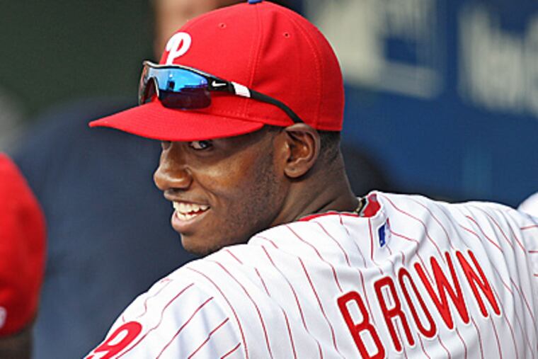 Domonic Brown was all smiles in the dugout before the start of Wednesday's game. (David M Warren/Staff Photographer)