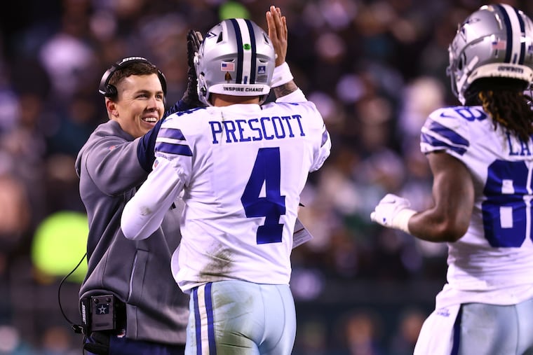 Dallas Cowboys offensive coordinator Kellen Moore congratulates quarterback Dak Prescott (4) during the first half of an NFL football game against the Philadelphia Eagles, Saturday, Jan. 8, 2022, in Philadelphia. The Cowboys defeated the Eagles 51-26. (AP Photo/Rich Schultz)