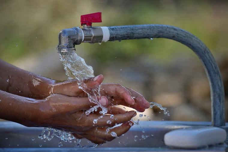 A Syrian refugee washes her hands after UNICEF workers bring water to a Syrian refugee camp to help contain a cholera outbreak, in Bhanine village, in the northern Akkar province, Lebanon, Tuesday, Oct. 18, 2022. In recent weeks, thousands of cholera cases have swept across the crisis-stricken countries of Lebanon, Syria, and Iraq. The three nations are struggling with depleted health care and water infrastructure, political and economic turmoil, and large populations of refugees and displaced people who live in overcrowded camps.