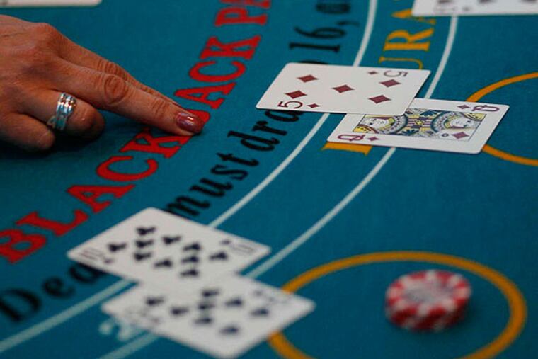 A dealer hands out cards at the blackjack table. ( Michael S. Wirtz / Staff Photographer )