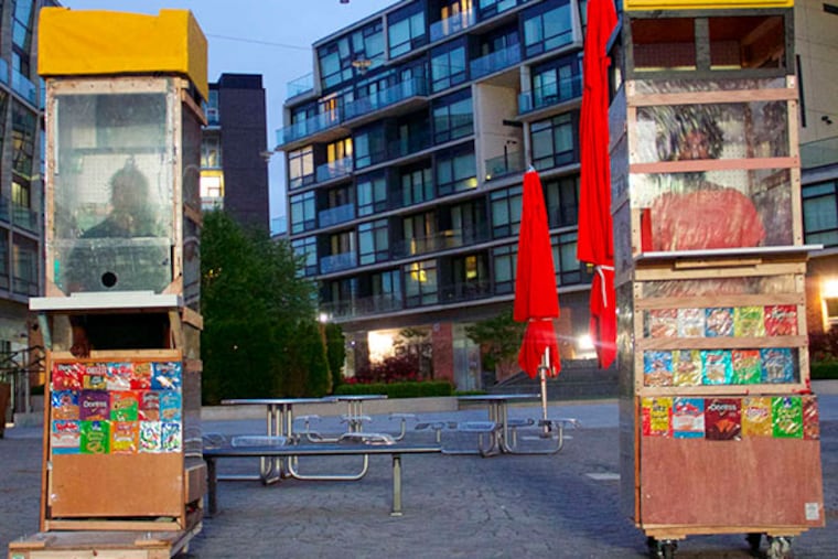 Ernel Martinez (left) and Keir Johnston of Amber Art and Design with their “Corner Store” performance piece at The Piazza at Schmidts in Philadelphia.
