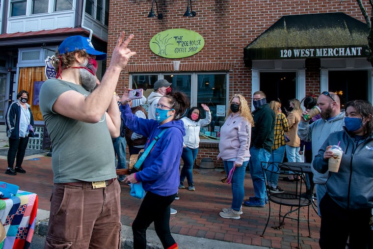 Co-owner Randy Van Osten (left) waves as the Treehouse Coffee Shop in Audubon hosts its "last call" Sunday after 18 years of operating and solidifying itself as a community staple. It's another victim of the coronavirus pandemic. Musician Sara O'Brien takes a cell phone video to mark the bittersweet closing that featured fond recollections.