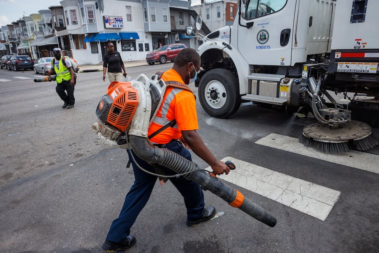 Workers with Future Track clean the street as part of Mayor Cherelle L. Parker's initiative to spruce up the city.