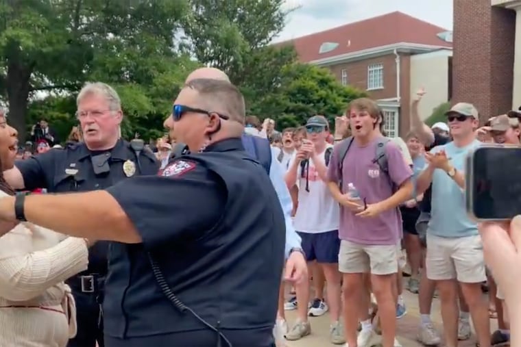 In this photo taken from video provided by Stacey J. Spiehler, a pro-Palestinian protester is confronted by hecklers at the University of Mississippi on Thursday. The hecklers vastly outnumbered pro-Palestinian demonstrators, and video shot by a student journalist showed one white heckler making monkey gestures and noises at a Black woman who was supporting pro-Palestinian protesters.