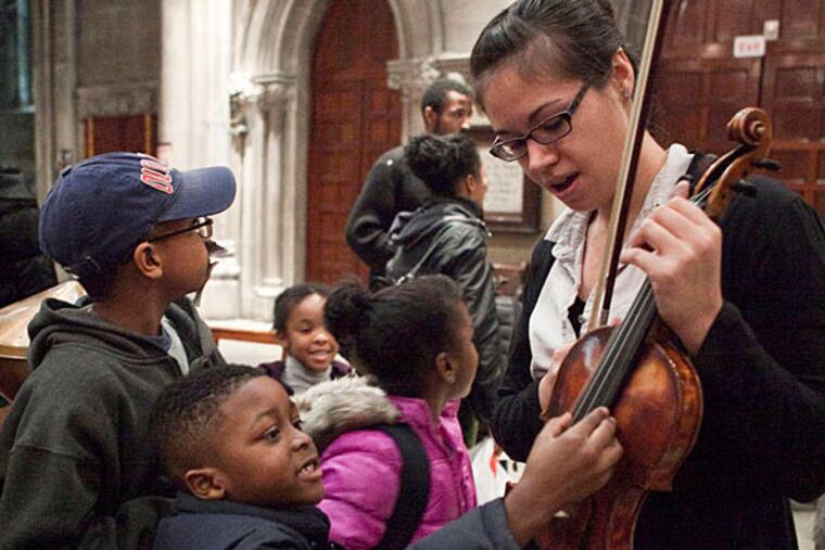Angela Sulzer gives the children a close look at her violin.
(Photo credit: Dana Scherer)
