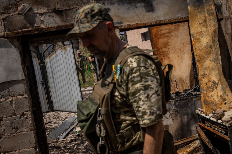 Commander of an artillery unit of the Ukrainian army, Mykhailo Strebizh, center, inside a destroyed house due to shelling in a village near the frontline in the Donetsk oblast region, eastern Ukraine, Thursday, June 2, 2022.