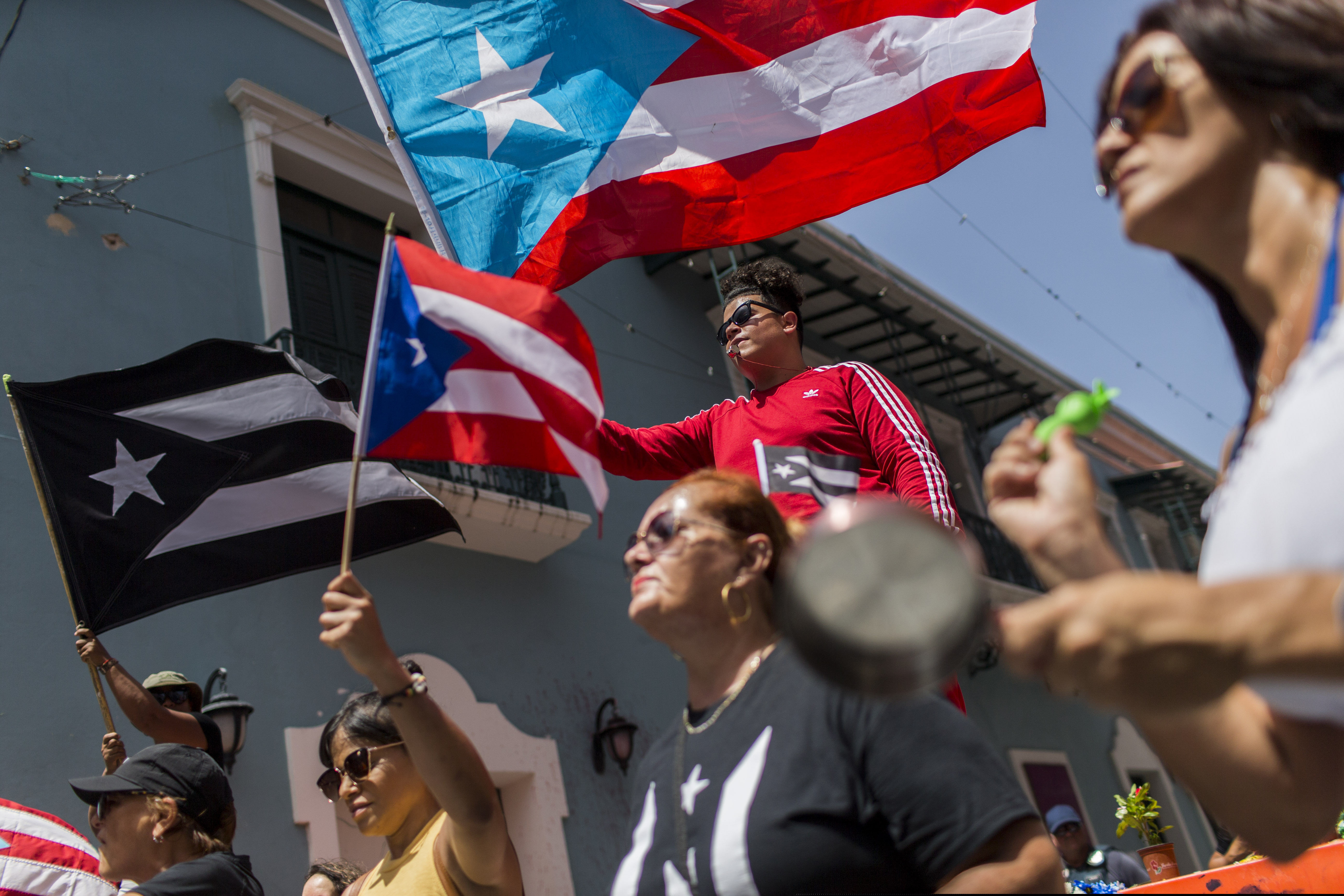 Demonstrators, some waving Puerto Rican national flags, gather in front of the governor's mansion La Fortaleza, in San Juan, Puerto Rico, on Wednesday.