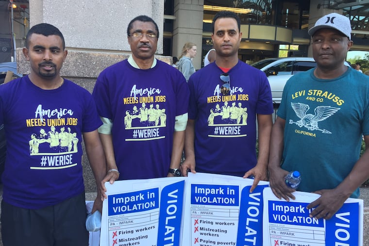 Fired Impark valets Surafel Fisiha, Fatoman Traore, Thomas Frezgi, and TK, during an action to protest the fired workers outside the Hospital of the University of Pennsylvania on June 29, 2018.