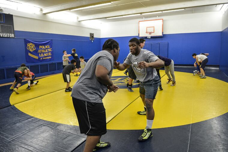 Southern wrestler Miles Lee (right) warms up with West Philly High
wrestler Ahraya Travis during a Beat the Streets Philadelphia
wresting program practice at the Police Athletic League in Port
Richmond.