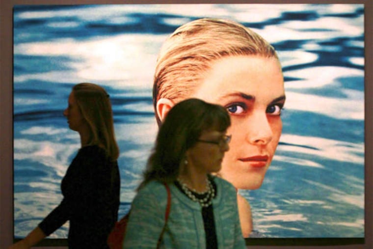 Grace Kelly is the star at an exhibit that opens Monday at the James A. Michener Art Museum in Doylestown. At a preview, Jessica Lawlor (left) of Visit Bucks County and H. Kristina Hauglaund of the Philadelphia Art Museum walk by a 1955 photograph.