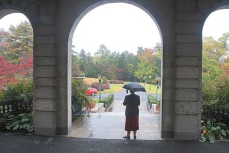 Sister Anne Lythgoe stands in the arches on the front side of Elstowe Manor on the Elkins Estate. ( Charles Fox / Staff Photographer )