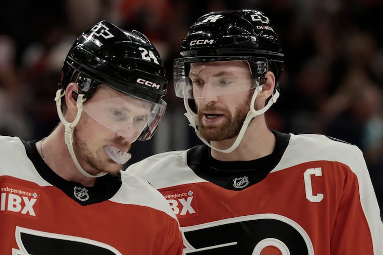 Sean Couturier (right) talks with teammate Nick Seeler against the Penguins on Oct. 28.