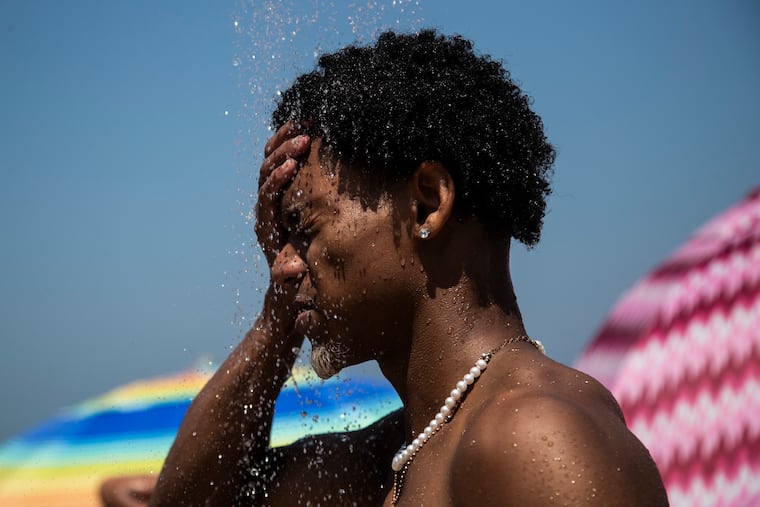 A man cools off in a shower at Ipanema beach, Rio de Janeiro, Brazil, in September. The latest calculations from several science agencies all say that global average temperatures for 2023 shattered existing heat records.