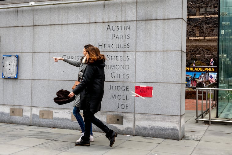 Signs and notes placed by visitors at the President's House in Independence National Historical Park in March. The Trump administration is bent on rewriting the history of the memorial, writes Sharon Ann Holt.