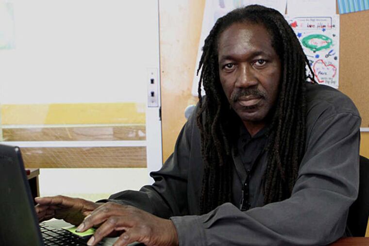 J. Jondhi Harrell works at his desk at Pathways to Housing PA. He spent more than 20 years in prison, and is now working on a Social Work master's and has started his own nonprofit, Center for Returning Citizens.