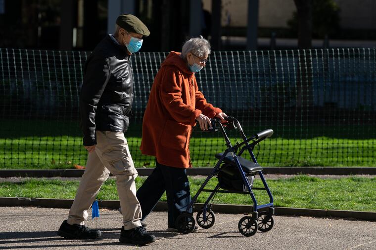 A couple walks through Rittenhouse Square in Philadelphia in April.