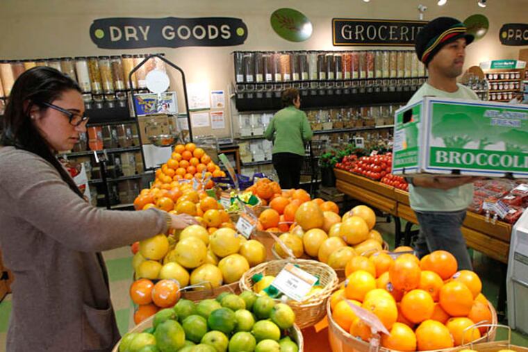 Angel Piazza, produce manager, and Kyle Jones, employee in the produce section at Creekside. More than 1,800 households are members - exceeding the 1,200 goal.