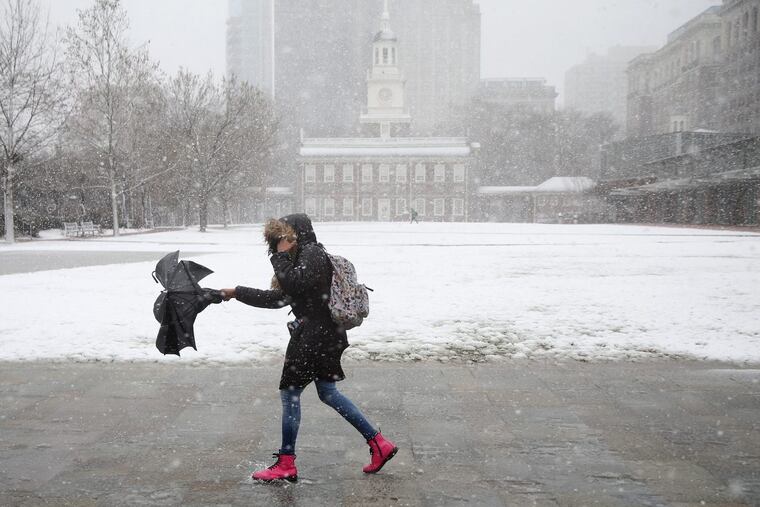 A woman braves the snow and wind along Independence Mall in Center City on Friday. Get ready for more.
