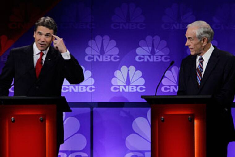 Republican presidential candidate Texas Gov. Rick Perry points his head as he speaks during a Republican Presidential Debate at Oakland University in Auburn Hills, Mich., Wednesday, Nov. 9, 2011. At right is Rep. Ron Paul, R-Texas. (AP Photo/Paul Sancya)
