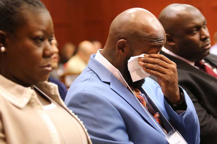 The father of Trayvon Martin, Tracy Martin, cries over the description of his son's death, at the George Zimmerman trial. Next to him are Sybrina Fulton, Trayvon's mother, and Daryl Parks, a family attorney.