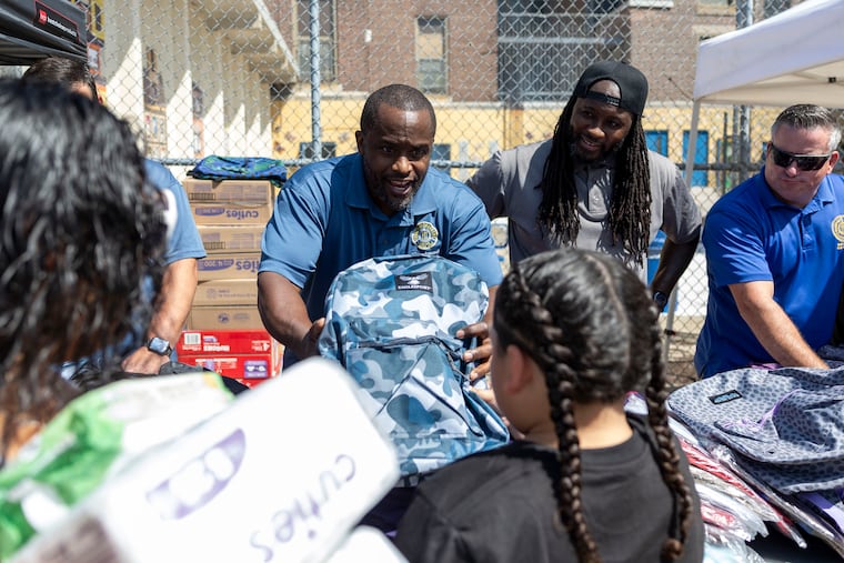 Marcelle Gibson, of North Philadelphia, business agent for TWU Local 234, meets Josyah Pratts, 9, a third grade student, during the Transport Workers Union Local 234 school supply giveaway at Alexander McClure Elementary.