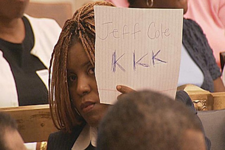 Latrice Bryant flashed a sign during a Council meeting in Sept.