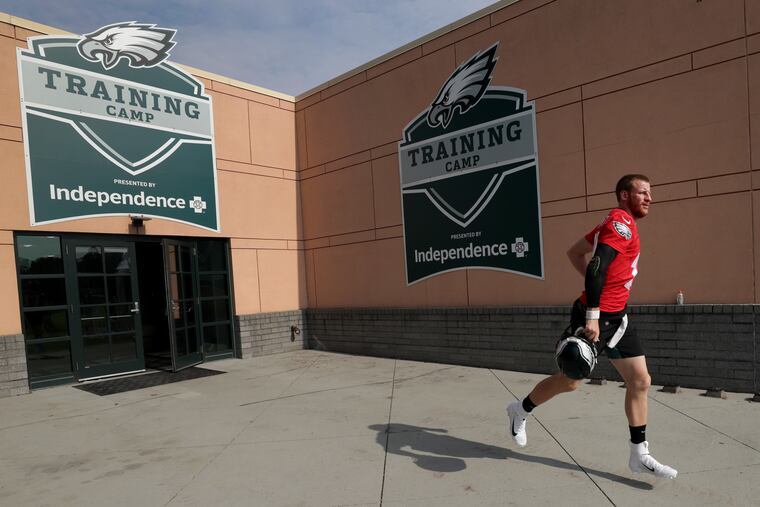 Eagles’ Carson Wentz jogs out to the practice field at the start of an Eagles training camp session.