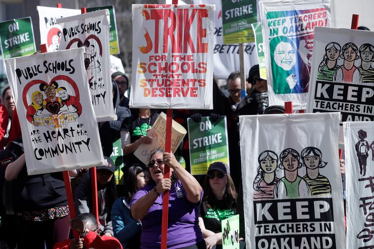 FILE - In this Thursday, Feb. 21, 2019, file photo, teachers, students, and supporters rally at Frank Ogawa Plaza in front of City Hall in Oakland, Calif.