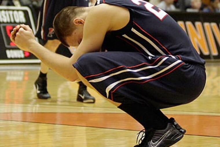 Penn's Jack Eggleston sits on the floor dejected after losing to Princeton in overtime. (Yong Kim/Staff Photographer)