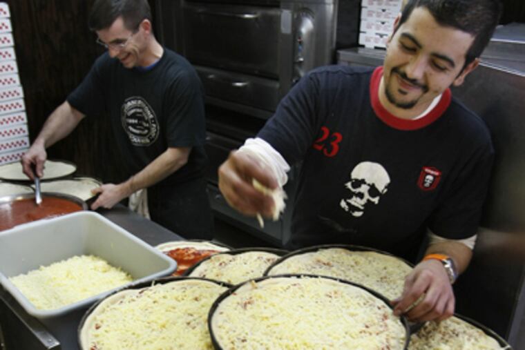 Dave Shearn (left), a co-owner of Cornerstone Pizza, and Kamal Jamai (right) prepare an order of 180 pizzas for U.S. Airways. (Michael S. Wirtz / Staff Photographer)