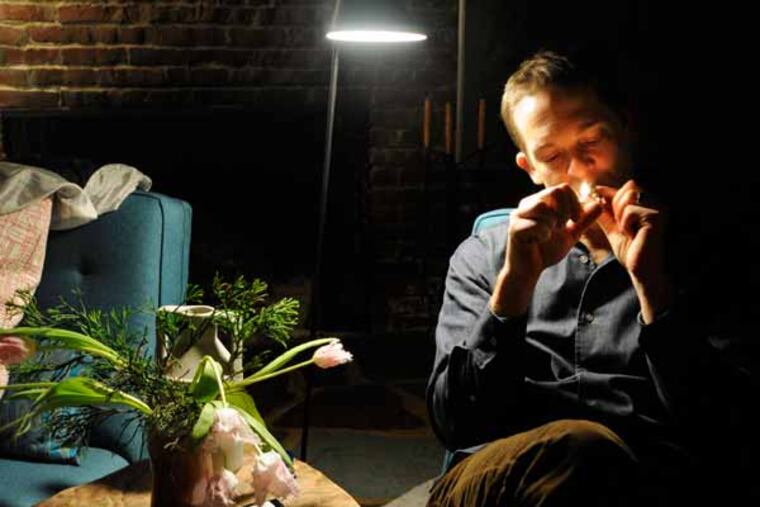 Jay Lassiter (cq) takes his first ever legal toke of medical marijuana at his home in Cherry Hill December 18, 2012. With a license to use medical marijuana to ease the side effects of his HIV medications, he had just made the the two hour drive home from Greenleaf Compassion Center in Montclair, NJ's only medical marijuana dispensary, where he picked up a legal bag of 3/4 ounces of medical marijuana. ( TOM GRALISH / Staff Photographer )