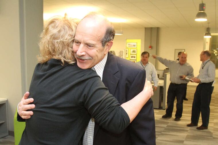Inquirer editor William K. Marimow gets a hug from business reporter Linda Loyd upon his return to the newsroom after the judge's decision.
