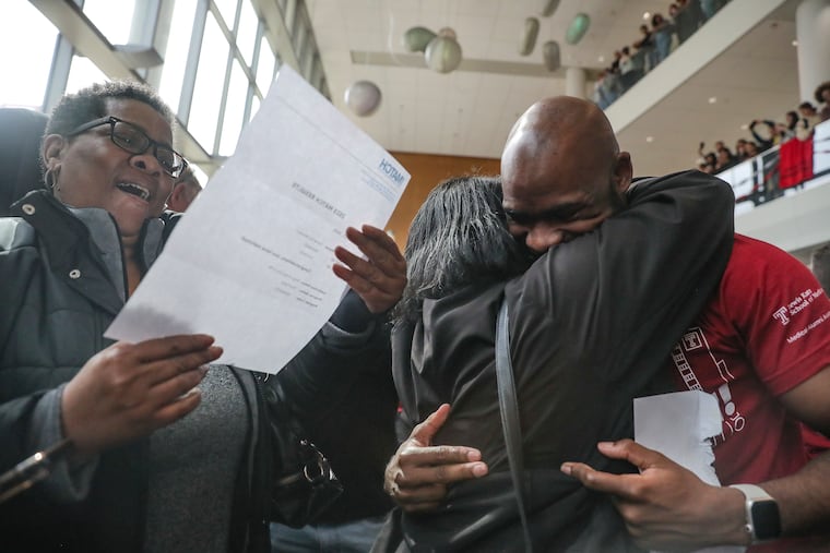 Demetrius Woodard hugs his mother, Denise Woodard, while his aunt, Cheryl Sully, reads his match results during a Match Day celebration at the Lewis Katz School of Medicine at Temple University in mid-March.