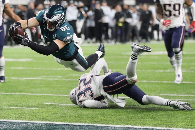 Eagles tight end Zach Ertz dives over New England Patriots defensive back Devin McCourty to score the winning touchdown in the fourth quarter of Super Bowl LII, at U.S. Bank Stadium in Minneapolis, Minnesota, Sunday, Feb. 4, 2018. The Eagles won 41-33. TIM TAI / Staff Photographer